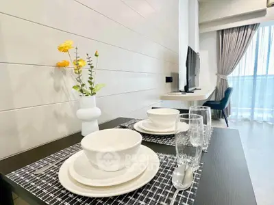 Modern dining area with elegant table setting and TV in a bright living space.