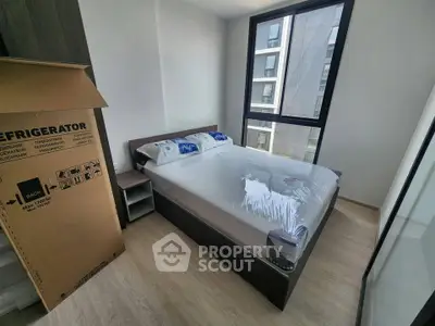 Modern bedroom with large window and new furniture in urban apartment