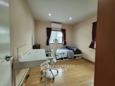 Cozy bedroom with study desk and modern decor, perfect for relaxation and productivity.