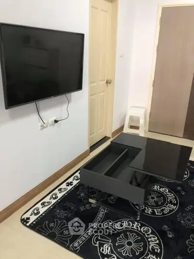Modern living room with wall-mounted TV and sleek black coffee table.