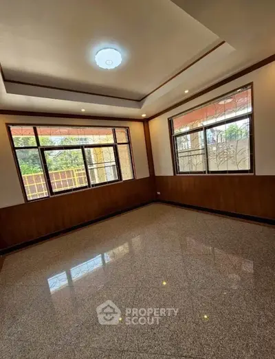 Spacious empty room with large windows and glossy tiled floor, perfect for customization.