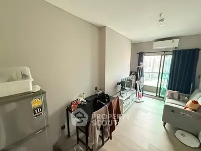 Cozy living room with balcony access and modern furnishings in urban apartment.