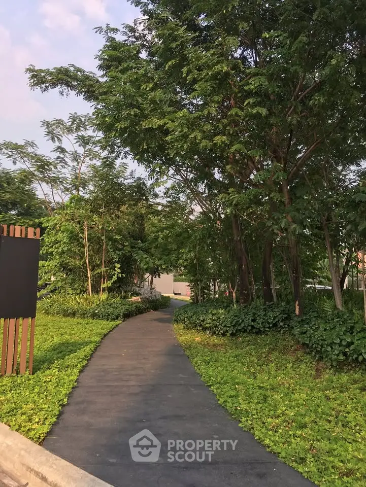 Serene garden pathway surrounded by lush greenery in a residential community.