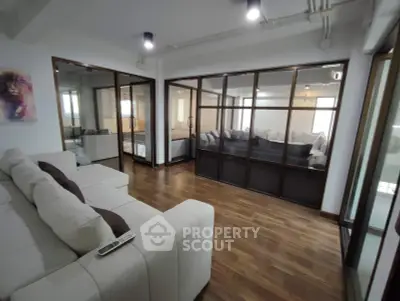 Spacious living room with modern glass partitions and cozy seating area
