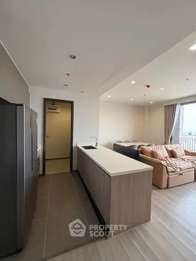Modern open-layout kitchen and living room with sleek design and natural light.