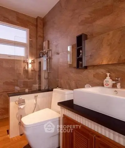 Luxurious bathroom with modern fixtures and elegant stone wall design.