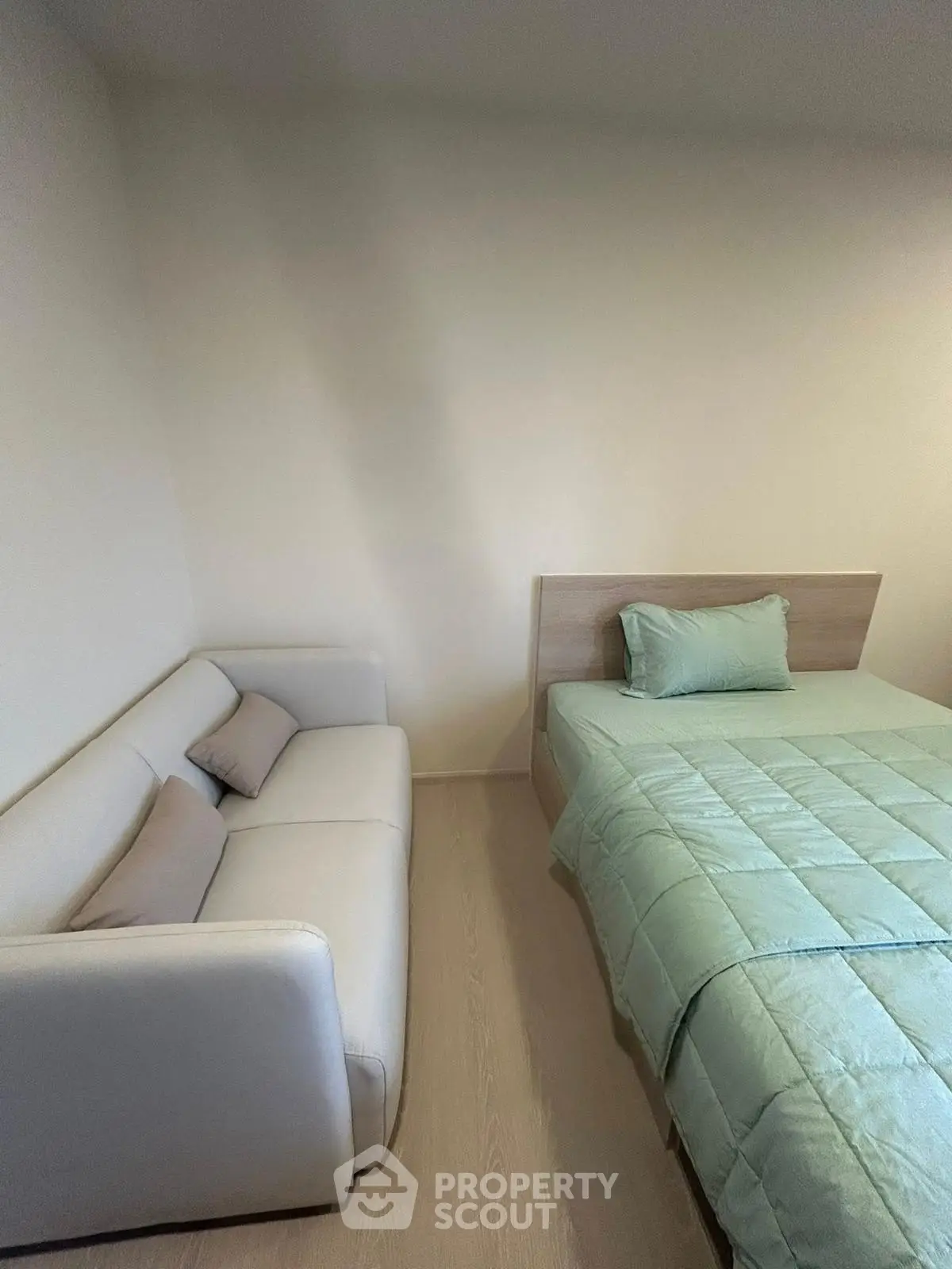 Cozy bedroom with modern sofa and stylish bedding, perfect for relaxation and comfort.