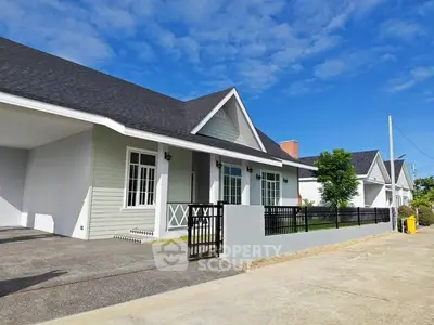 Charming single-story home with modern design and spacious driveway under clear blue skies.