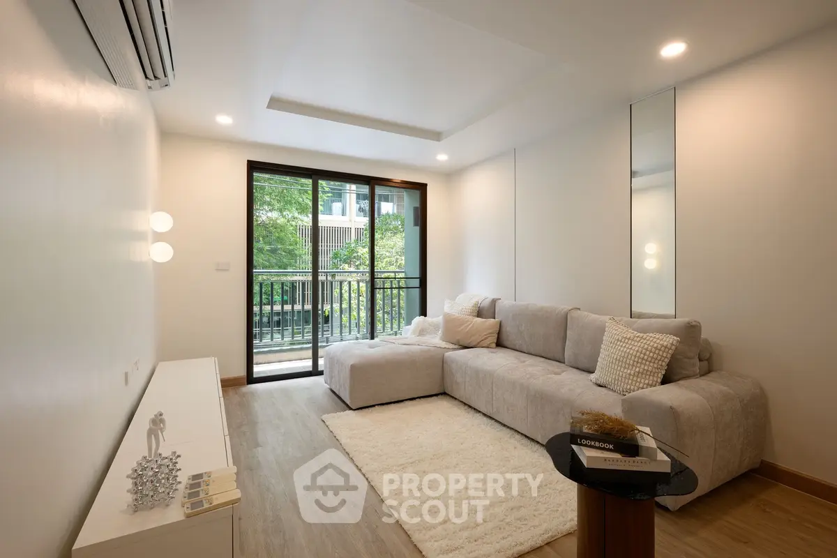 Modern living room with cozy sofa and balcony view in a stylish apartment.