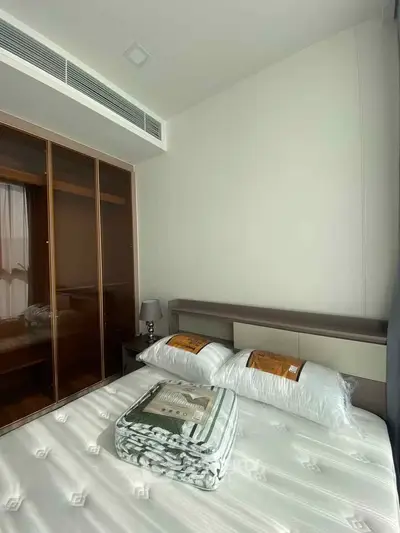 Modern bedroom with stylish wardrobe and cozy bedding in a contemporary apartment.