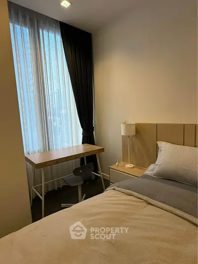 Cozy bedroom with study desk and modern decor, perfect for comfortable living.