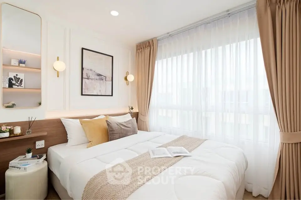 Bright and cozy bedroom with elegant decor and large window for natural light.