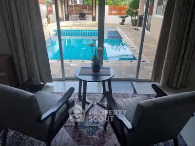 Charming poolside view from cozy living room with elegant decor and natural light.