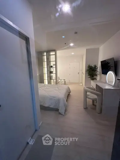 Modern bedroom with sleek design and ambient lighting, featuring a cozy bed and stylish decor.