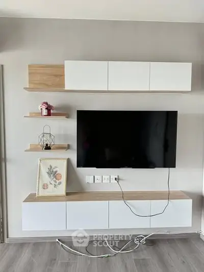 Modern living room with wall-mounted TV and sleek storage units.
