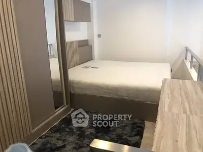 Modern bedroom with stylish decor and plush carpet in a contemporary apartment.