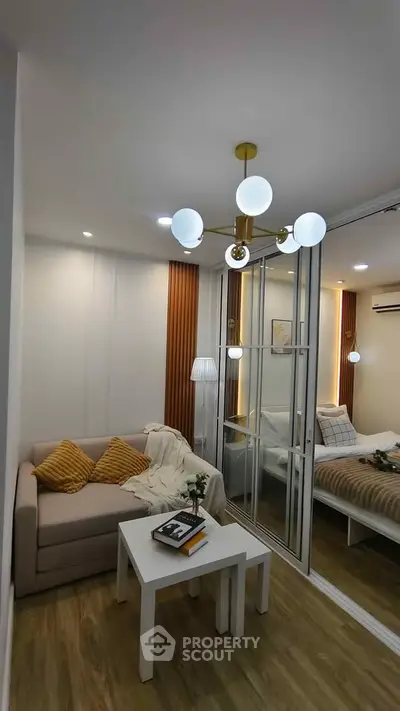 Modern living room with cozy sofa and stylish lighting in a compact apartment.