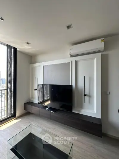 Modern living room with sleek TV unit and air conditioning, featuring a city view balcony.