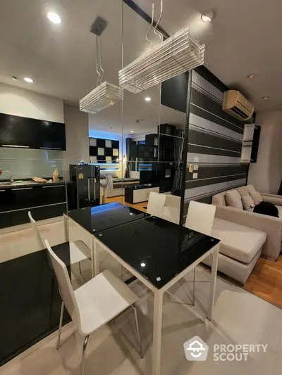 Modern open-layout living room with sleek black and white decor and dining area