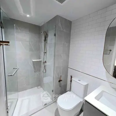 Modern bathroom with glass shower, sleek tiles, and contemporary fixtures.