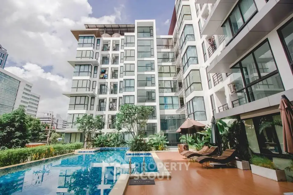 Modern apartment building with pool and lush greenery, perfect for urban living.