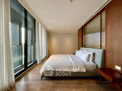 Luxurious bedroom with floor-to-ceiling windows and elegant wooden accents