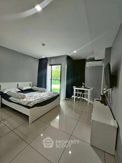 Modern bedroom with sleek design, large windows, and stylish furnishings in a contemporary apartment.