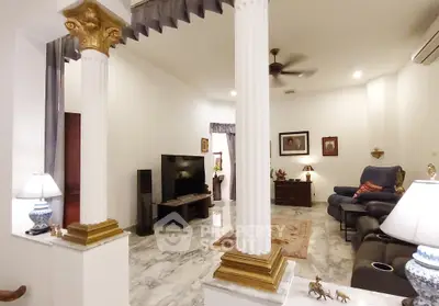 Elegant living room with marble flooring, decorative columns, and cozy seating area.