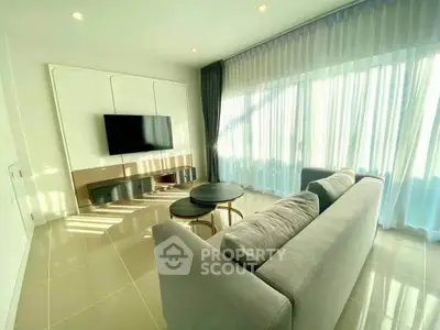 Bright and modern living room with large windows and sleek furnishings, perfect for relaxation and entertainment.