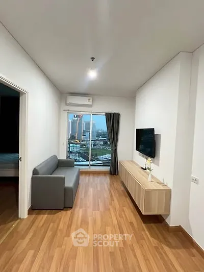 Modern living room with city view, sleek furniture, and wooden flooring in a high-rise apartment.