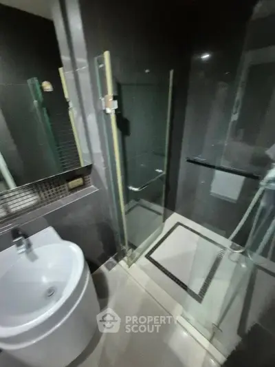 Modern bathroom with sleek glass shower and stylish sink in contemporary design.