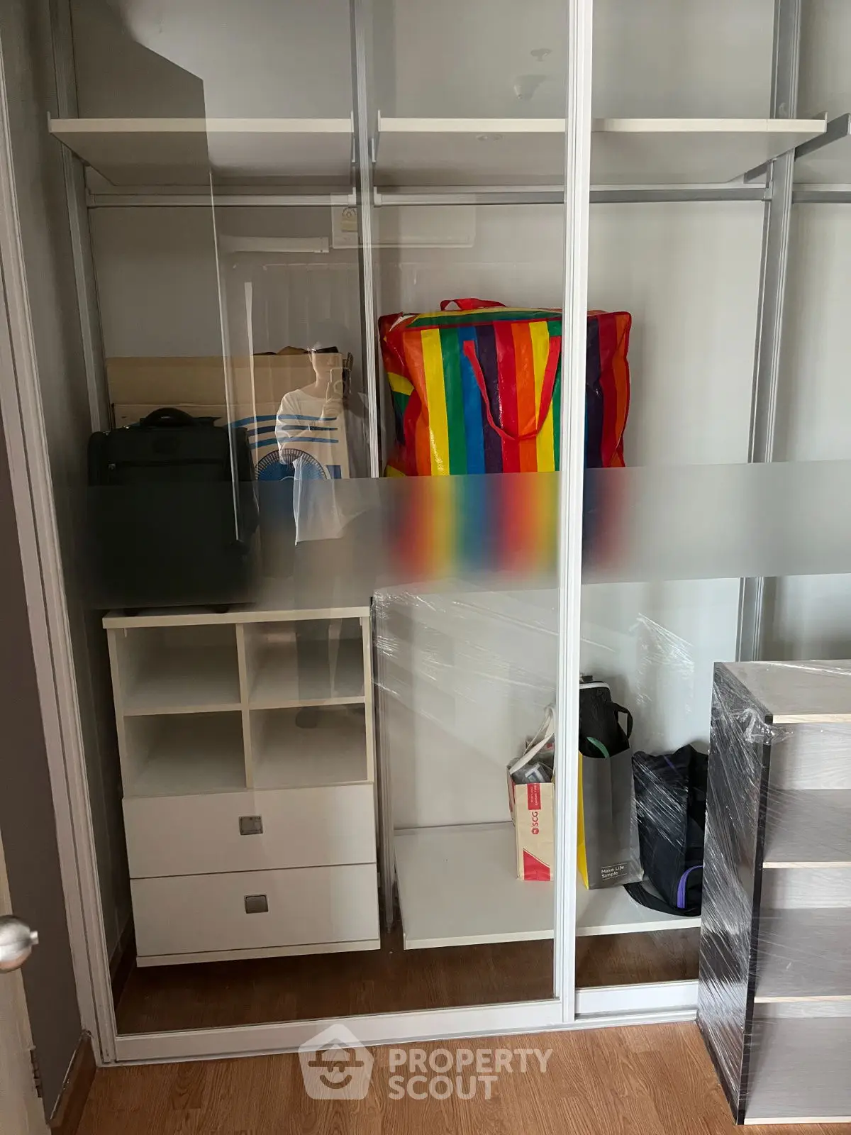 Spacious storage closet with sliding glass doors and organized shelving.