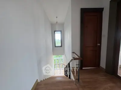 Bright stairway with wooden flooring and window view in modern home