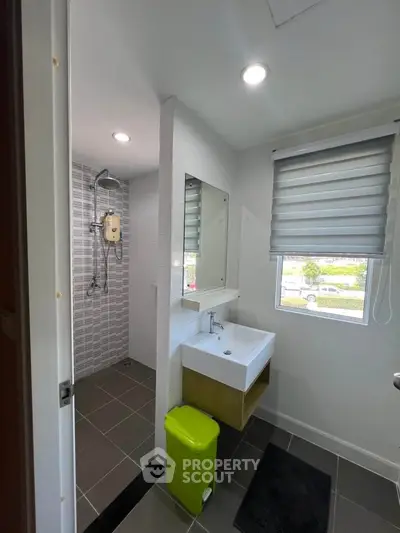 Modern bathroom with sleek fixtures and large window offering natural light.