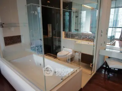 Luxurious modern bathroom with glass shower and large bathtub in upscale apartment.