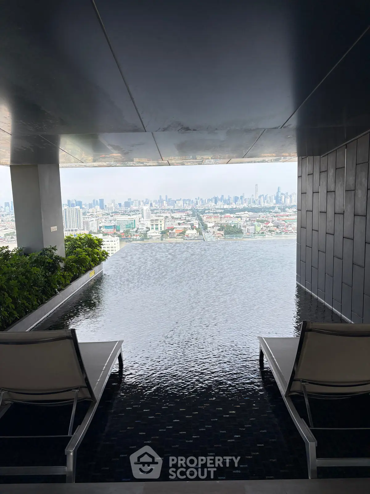 Luxurious rooftop infinity pool with stunning city skyline view, perfect for relaxation and leisure.