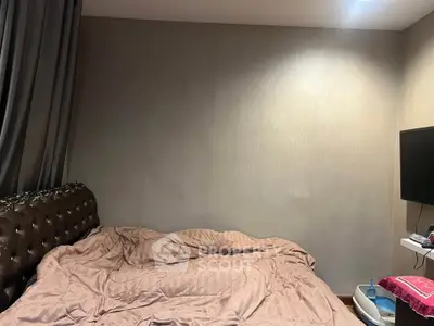 Cozy bedroom with plush bedding and wall-mounted TV, perfect for relaxation.