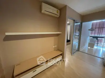 Modern apartment interior with air conditioning and sliding glass doors leading to a bright dining area.