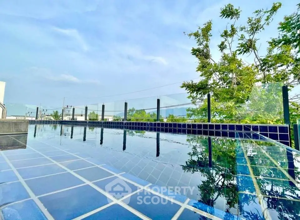 Stunning rooftop pool with glass railing and city views