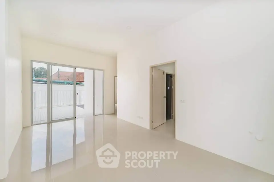 Spacious and bright living room with large windows and glossy floors, perfect for modern living.