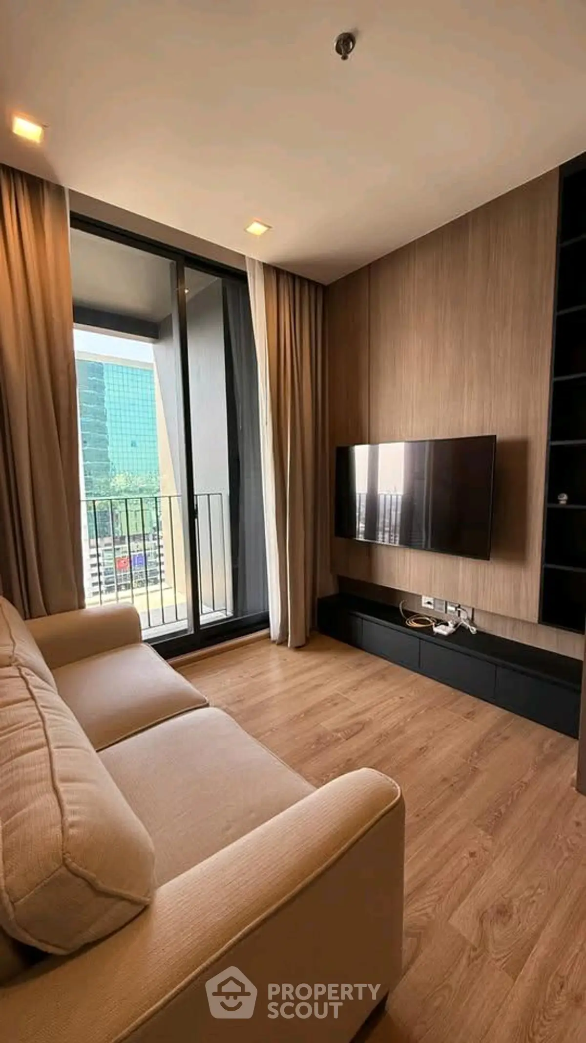 Modern living room with balcony view and wall-mounted TV