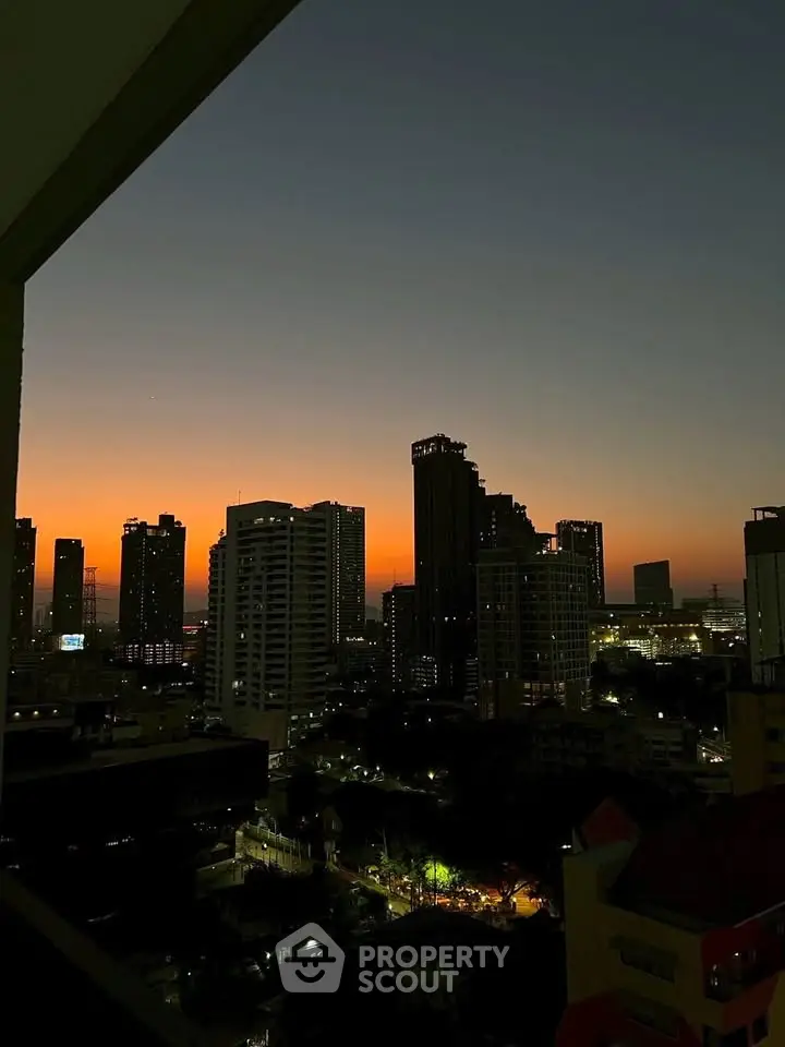 Stunning city skyline view at sunset from a high-rise balcony, showcasing urban living.