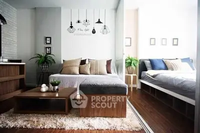 Modern living room with stylish decor and cozy bedroom in open layout apartment.