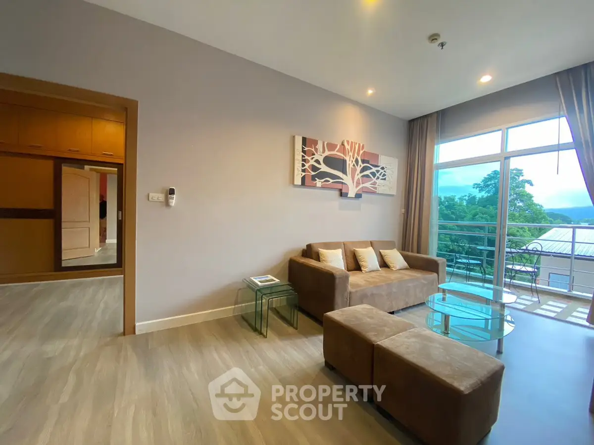 Spacious living room with modern decor and large windows offering scenic views.