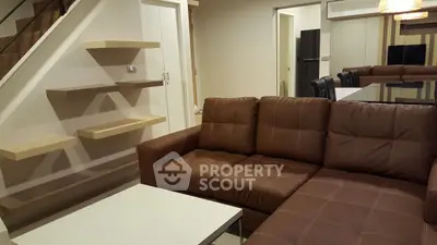 Modern living room with brown leather sofa and floating shelves