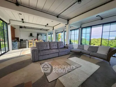 Spacious modern living room with panoramic windows and stylish furniture