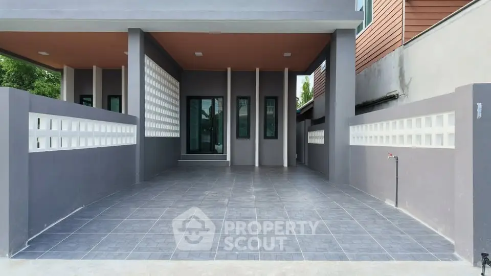 Modern home entrance with spacious tiled driveway and sleek design