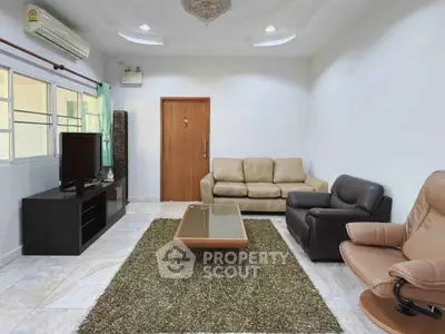 Spacious living room with modern furniture and natural light, perfect for relaxation and entertainment.