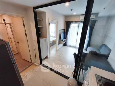 Modern apartment with open layout, featuring a cozy living room and adjacent kitchen area.