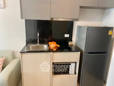 Modern compact kitchen with sleek appliances and stylish cabinetry, perfect for urban living.